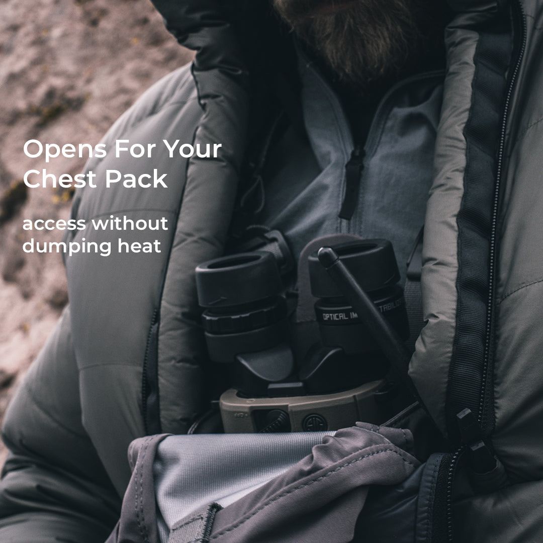 A close-up lifestyle shot of a person wearing a gray puffer jacket and holding a binocular case against their chest. White text on the left reads 'Opens For Your Chest Gear' and 'access without dumping heat'.