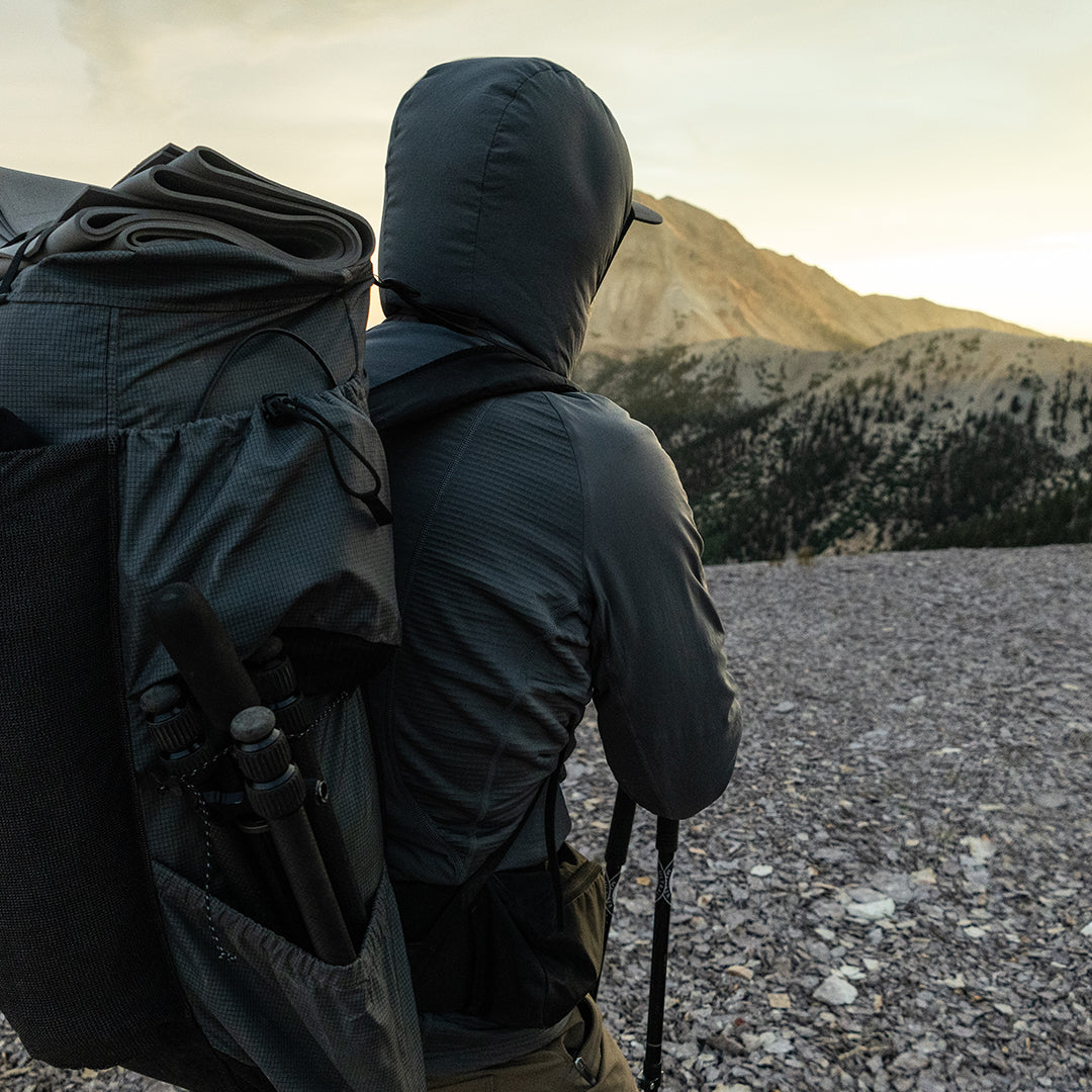 rear view of man wearing hybrid fleece hoodie on mountain peak