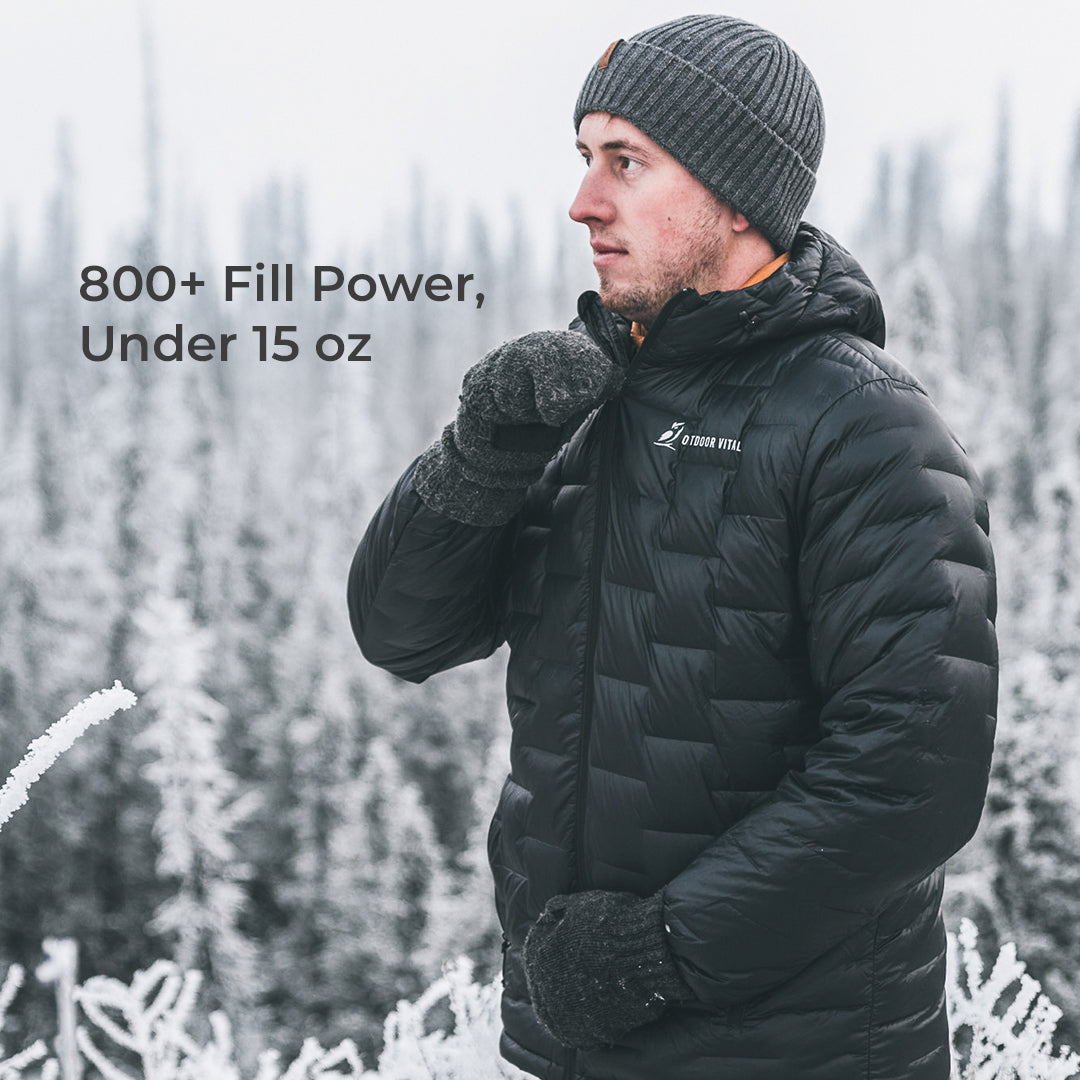 A man wearing a black puffer jacket, gray knit beanie, and black gloves stands in a snowy outdoor setting. Text on the left reads '800+ Fill Power, Under 15 oz.