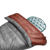 Close-up view of the red Outdoor Vitals StormLoft Down TopQuilt pulled down to reveal its soft inner lining, paired with an inflatable sleeping pad setup.