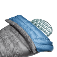 Close-up view of the blue Outdoor Vitals StormLoft Down TopQuilt pulled down to reveal its soft inner lining, paired with an inflatable sleeping pad setup.