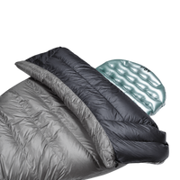 Close-up view of the black 40 degree Outdoor Vitals StormLoft Down TopQuilt pulled down to reveal its soft inner lining, paired with an inflatable sleeping pad setup.