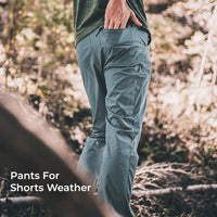 person wearing blue joggers in wooded area. "Pants For Shorts Weather" is overlaid in the bottom left.