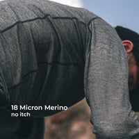 A close-up of a person wearing a long-sleeve wool athletic shirt, shown outdoors with text overlay reading '18 Micron Merino no itch'.