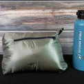 Packed NovaPro jacket beside a water bottle for size comparison
